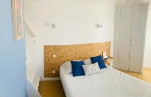 图卢兹蒂博公寓的一间卧室配有白色床和蓝色枕头