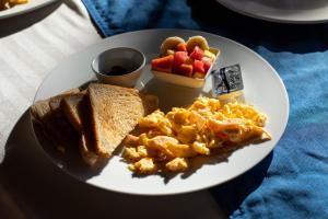 博卡奇卡Roxy's Bed & Breakfast的包括鸡蛋烤面包和水果的早餐盘