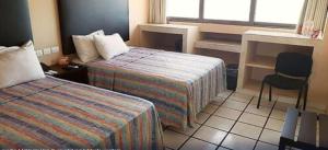 夸察夸尔科斯Hotel Terrasol的酒店客房 - 带两张床、一张桌子和一把椅子