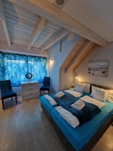 韦巴Apartamenty Polanki 2 - Sauna, Jacuzzi, Podgrzewany Basen的一间卧室配有一张大床和两把椅子