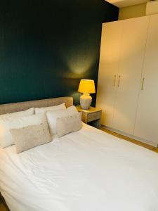 温特和克DMN City at Merensky Apartment的一间卧室配有一张白色的床和绿色的墙壁