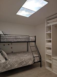 科巴罗Apartamento playa de Chancelas, Pontevedra的一间卧室配有一张双层床和天窗