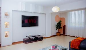 达累斯萨拉姆The Notch的一间客厅,在白色的墙上配有电视