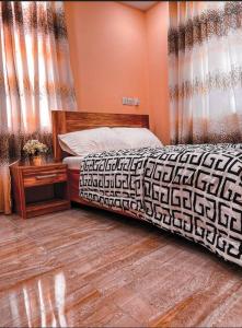 AshaimanRabban Apartment的一间卧室配有床和窗帘,铺有木地板