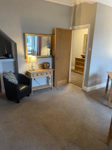 锡豪西斯Horncliffe room only accommodation的客厅配有椅子、桌子和镜子