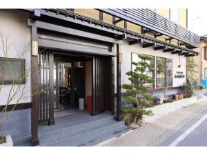草津Kusatsu Onsen 326 Yamanoyu Hotel - Vacation STAY 10349v的外边有树的建筑物的前门