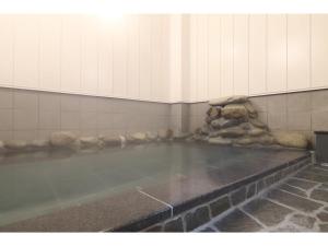 草津Kusatsu Onsen 326 Yamanoyu Hotel - Vacation STAY 10349v的石墙房间里一大团水