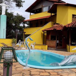 圣安娜杜里亚舒Nova Pousada Sollaris - Coração da Serra do Cipó - MG的一座游泳池,在房子前有海豚雕像
