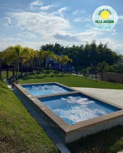 拉特瓦伊达Villa Jackson的公园旁草地上的游泳池