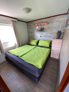 德科赫Beachhouses Texel的一间卧室配有一张带绿色床单的大床