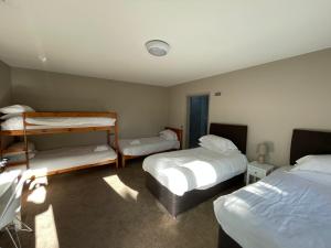拉斯盖特保图姆Tall Pines Lodges的一间客房配有两张床和两张双层床。