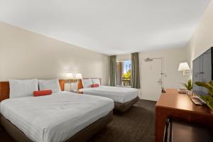 博伟公园晚安普安那公园酒店的酒店客房配有两张床和一张书桌