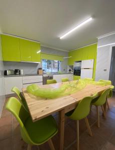 吉尔斯Cantinho Verde T3的厨房配有木桌和绿色椅子