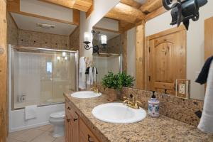 白鱼镇The Grand Alpine Lodge的一间带两个盥洗盆和淋浴的浴室
