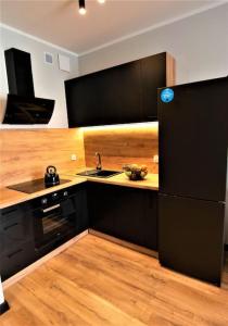 苏瓦乌基Apartament Blisko Centrum的厨房配有黑色橱柜和黑色冰箱。