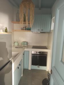 阿莫尔戈斯Idothea guest house的厨房配有蓝色橱柜和炉灶烤箱。
