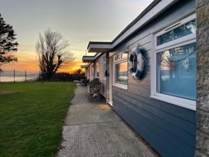 桑当Wight Waves Holidays的蓝色建筑,背景是日落
