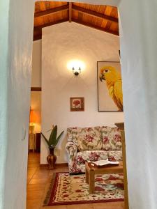 摩亚BELLA DORAMAS Casas Rurales Panchita & Millo的客厅配有沙发和墙上的鹦鹉