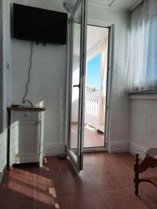洛帕Apartmani Ana-Lora的客房设有滑动玻璃门,可通往阳台