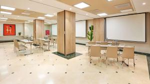 马德里NH系列马德里阿瓦斯卡尔酒店的一间会议室,配有桌椅和白板