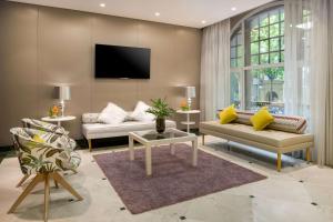 马德里NH系列马德里阿瓦斯卡尔酒店的客厅配有两张沙发和一台电视机