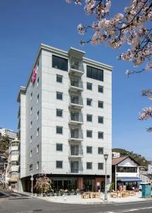 尾道市Sakura Hotel Onomichi Ekimae的一条城市街道上高大的白色建筑