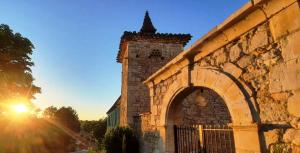 LamillariéDOMAINE DE LEJOS - Portes d'Albi的一座古老的石头建筑,设有大门,享有日落美景