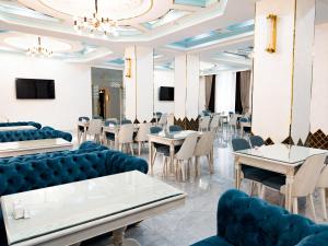 塔什干Reikartz Amirun Tashkent的一间配备有蓝色椅子和桌子的用餐室