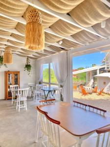 因比图巴Pousada Maria Parafina Praia do Rosa的一间设有木制天花板和桌椅的用餐室