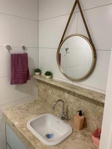 若昂佩索阿Apt beira-mar Cabo Branco的浴室设有水槽和镜子,位于柜台上