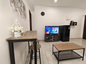大山脚【NEW】Cozy&Warm Studio@Juru Sentral Icon City的客厅配有桌子和电视