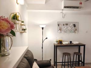 大山脚【NEW】Cozy&Warm Studio@Juru Sentral Icon City的客厅配有桌子、两张凳子和一盏灯