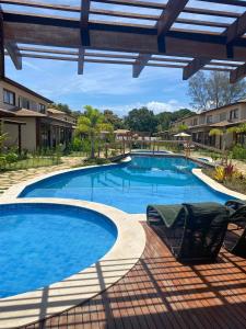 巴拉格兰德Condominio Viva Barra的庭院内一个带两把椅子的大型游泳池