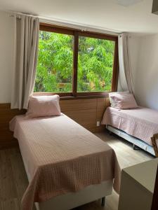 巴拉格兰德Condominio Viva Barra的带窗户的客房内的两张床