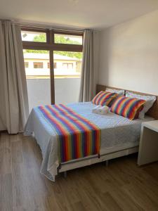 巴拉格兰德Condominio Viva Barra的一间卧室设有一张大床和大窗户