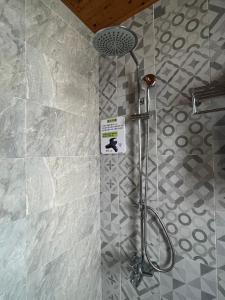 花莲市今古安民宿 - 步行東大門夜市3分鐘的浴室设有淋浴,墙上有标志
