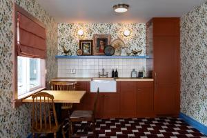 大熊湖NP Boutique Lodge的厨房配有红色橱柜、桌子和水槽