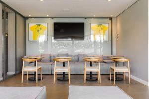 弗洛里亚诺波利斯Patio Milano Apartamentos completos em condominio incrivel com food hall的餐厅设有木桌、椅子和电视。