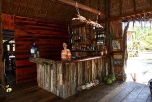 瓜隆岛Lily's Riverhouse的站在酒吧后面的女人,在小屋里