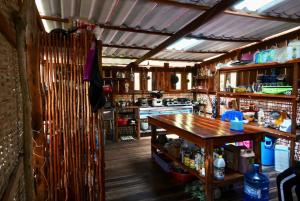 瓜隆岛Lily's Riverhouse的厨房铺有木地板,配有木桌。