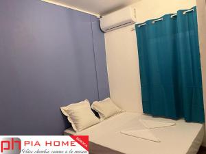 MamoudzouPIA HOME La Pompe的小房间设有一张带蓝色淋浴帘的床