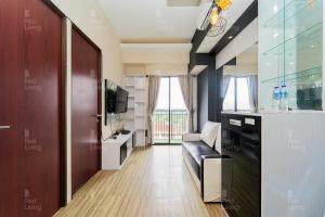 万隆RedLiving Apartemen Tamansari Panoramic - Santuy Agency Lobby P1 9的客厅配有沙发和电视。