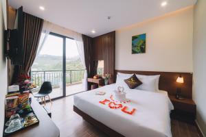 大叻GREENECO DA LAT HOTEL - Khách sạn Green Eco Đà Lạt的酒店客房设有一张床和一个阳台。