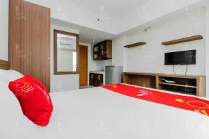 庞多克辛纳RedLiving Apartemen Margonda Residence 2 - Tower 2的卧室配有一张大白色床和红色枕头