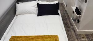 博勒姆伍德London gateway studio flat的一张带黑色枕头和白色枕头的床
