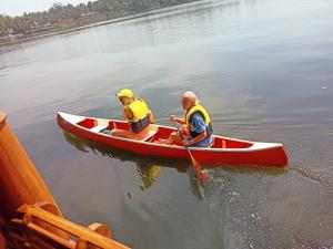 奎隆阿什塔目迪旅馆的水面上两个男人在红船里