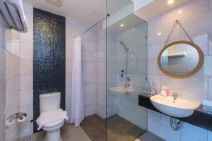 安汶Rumaruma Farvet Residence @ Ambon的一间带卫生间、水槽和镜子的浴室