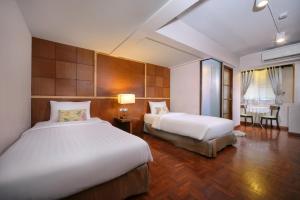 清迈清迈伊斯提亚酒店-SHA Plus的酒店客房设有两张床和一张桌子。