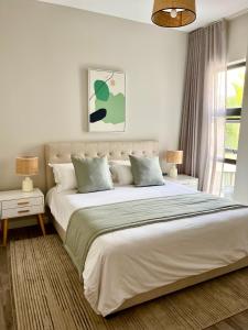 贝尔马尔Tropical beachfront apartment的白色的卧室设有一张大床和一个窗户