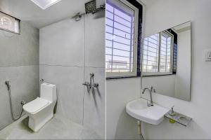 浦那FabHotel Galaxy Stay的一间带水槽、卫生间和镜子的浴室